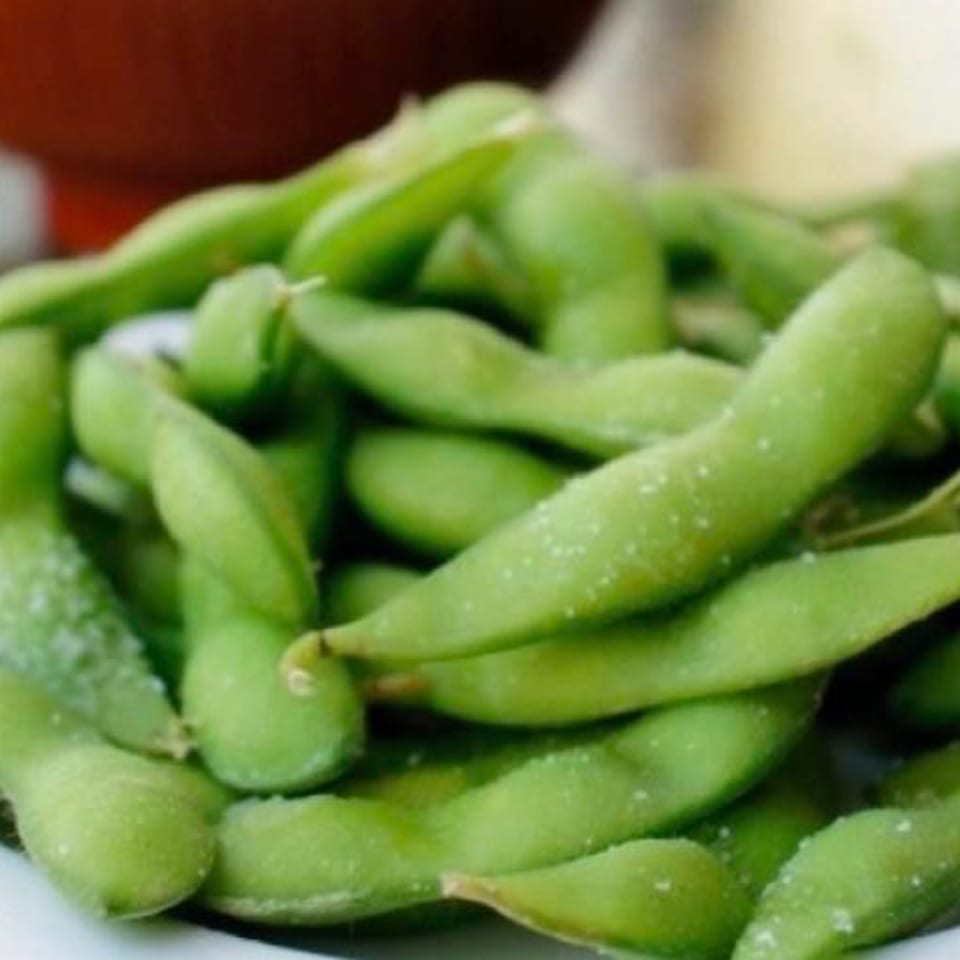 Close-up of a pile of salted edamame pods, a popular appetizer at Red Lotus Noodle House.