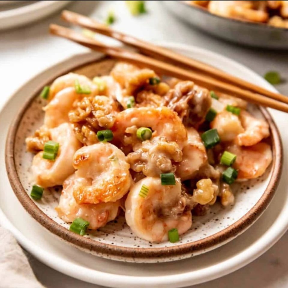 Honey walnut shrimp with green onions on a speckled plate with chopsticks at Red Lotus Noodle House.
